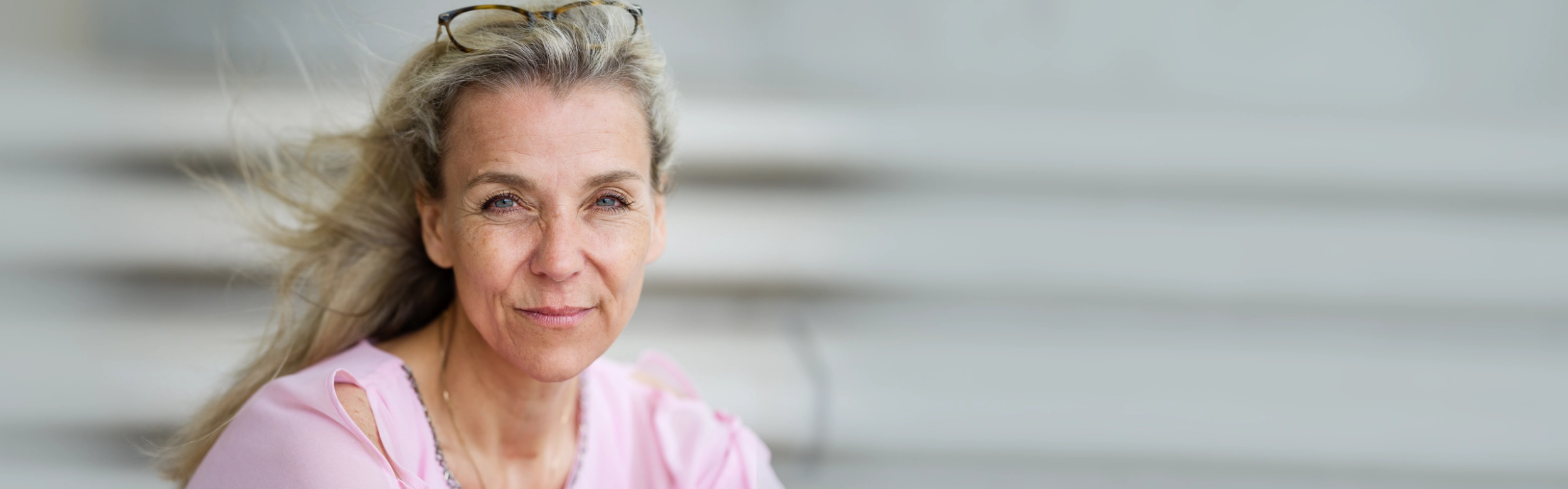 Rosa schraeg sitzend vor hellgrauem Grund